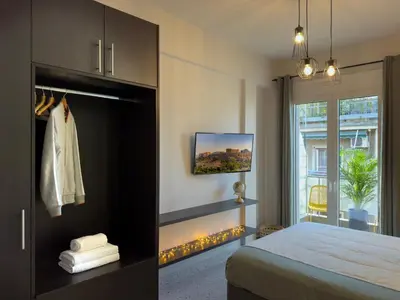 a bedroom with a bed and a tv and a window at Luxury Studio with Panoramic Views in Athens