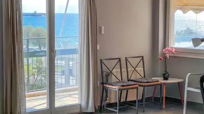 a room with two chairs and a table and a window at Alimos Sea View Family Apartment in Athens