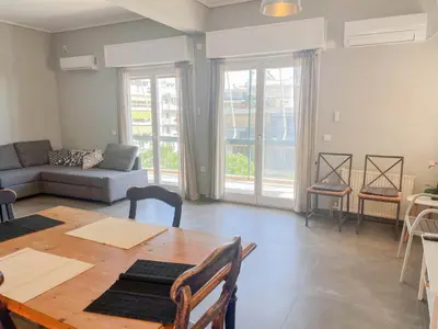 a living room with a table and a couch at Alimos Sea View Family Apartment in Athens