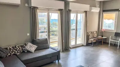 a living room with a couch and large windows at Alimos Sea View Family Apartment in Athens