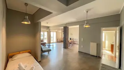 a bedroom with a bed and a living room at Alimos Sea View Family Apartment in Athens
