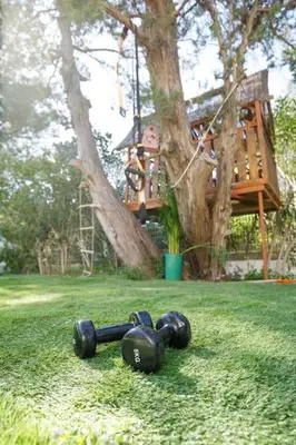 a person in a tree house with weights on the grass at Dreamy relaxing secluded Villa Aurora in Palaiá Fókaia