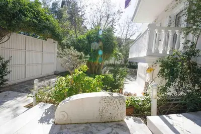 a garden in front of a house with a fence at Dreamy relaxing secluded Villa Aurora in Palaiá Fókaia