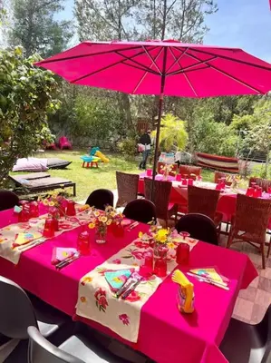 a table with a pink table cloth and an umbrella at Dreamy relaxing secluded Villa Aurora in Palaiá Fókaia