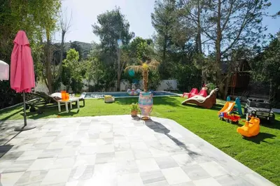 a backyard with a playground and a pool with people playing at Dreamy relaxing secluded Villa Aurora in Palaiá Fókaia