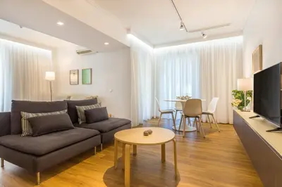 a living room with a couch and a table at Elegance Vouliagmeni Gem Luxury Apt, Walk to Beach in Athens