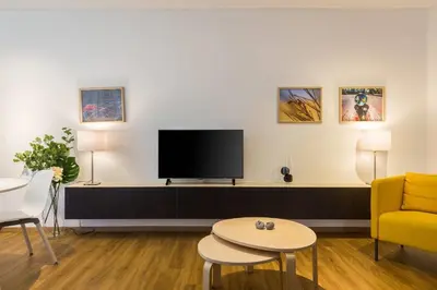a living room with a tv and a couch and a table at Elegance Vouliagmeni Gem Luxury Apt, Walk to Beach in Athens