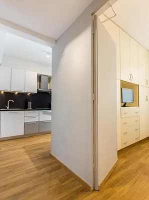 a large kitchen with white cabinets and a sliding door at Elegance Vouliagmeni Gem Luxury Apt, Walk to Beach in Athens