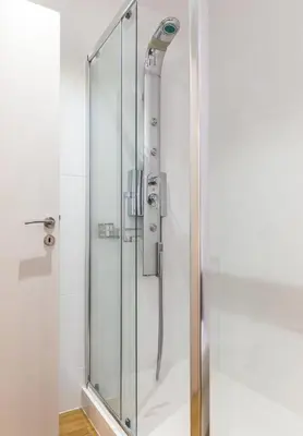 a shower stall with a glass shower door at Elegance Vouliagmeni Gem Luxury Apt, Walk to Beach in Athens