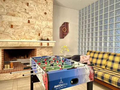 a living room with a foosball table in front of a fireplace at Glyfada Grand Residence in Athens