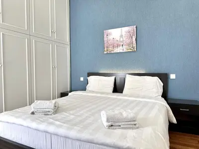 a bedroom with a large white bed with towels on it at Glyfada Grand Residence in Athens