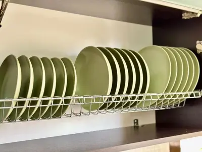 a row of plates on a shelf in a kitchen at Glyfada Grand Residence in Athens