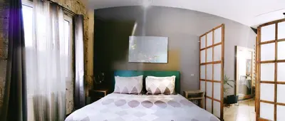 a bedroom with a bed with a green headboard at Page55 in Piraeus