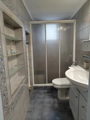 a bathroom with a shower and a toilet and a sink at Page55 in Piraeus