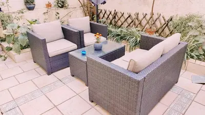 two wicker chairs and a table on a patio at Page55 in Piraeus