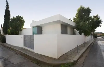 a white building on the side of a street at ΒΙΛΑ ΜΕ ΠΙΣΙΝΑ ΣΤΗΝ ΠΑΙΑΝΙΑ in Paianía