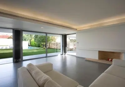 a living room with a white couch and large windows at ΒΙΛΑ ΜΕ ΠΙΣΙΝΑ ΣΤΗΝ ΠΑΙΑΝΙΑ in Paianía