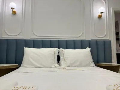 a bed with white pillows and a blue head board at White House Vouliagmeni 3-Free Parking ,Near the Sea in Athens