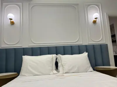 a bedroom with a bed with two lights on the wall at White House Vouliagmeni 3-Free Parking ,Near the Sea in Athens