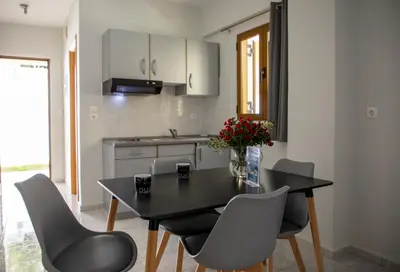 a kitchen with a black table and chairs and a sink at Anesis Apartments in Agia Marina Aegina