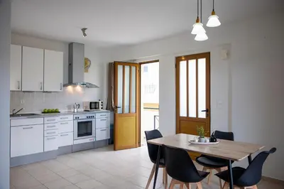 a kitchen with a wooden table and a table and chairs at Anesis Apartments in Agia Marina Aegina