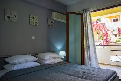 a bedroom with a bed with two pillows and a window at Anesis Apartments in Agia Marina Aegina