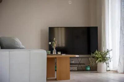 a living room with a tv and a table at Anesis Apartments in Agia Marina Aegina