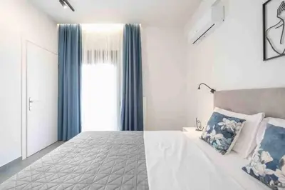 a bedroom with a large bed with blue curtains at Cozy apartment in a new building apartment 2 in Piraeus