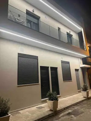a building with black shuttered windows and a balcony at Cozy apartment in a new building apartment 2 in Piraeus