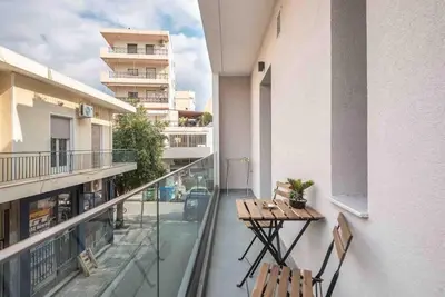 a balcony with two tables and chairs on a building at Cozy apartment in a new building apartment 2 in Piraeus