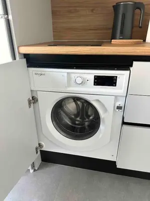 a kitchen with a washing machine under a counter at Cozy apartment in a new building apartment 2 in Piraeus