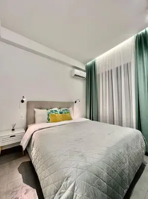 a bedroom with a large bed and green curtains at Cozy apartment in a new building apartment 3 in Piraeus
