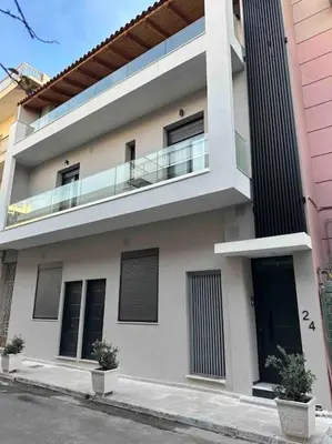 a white building with a balcony on the side of it at Cozy apartment in a new building apartment 3 in Piraeus
