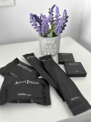 a table with three black cards and a vase of flowers at Cozy apartment in a new building apartment 3 in Piraeus