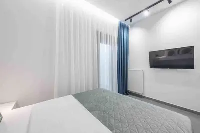 a bedroom with a bed and a tv on the wall at Cozy apartment in a new building apartment 4 in Piraeus