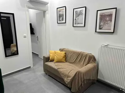 a living room with a couch with a yellow pillow at Cozy apartment in a new building apartment 4 in Piraeus