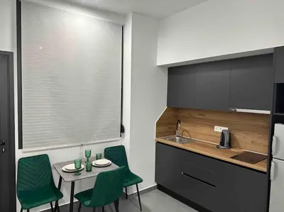 a kitchen with a small table and green chairs at Cozy apartment in a new building apartment 4 in Piraeus