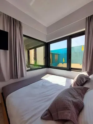 a bedroom with a large bed with a large window at BlueMotion - CruiseNest 143 5B in Piraeus