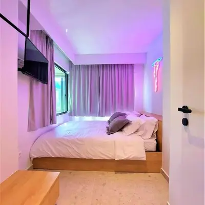 a bedroom with a large bed with purple lighting at BlueMotion - CruiseNest 143 5B in Piraeus