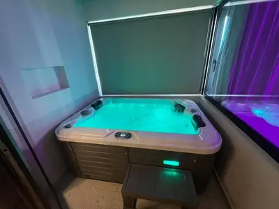 a bathroom with a tub with a purple and green water at BlueMotion - CruiseNest 143 5B in Piraeus