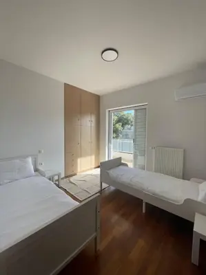 a bedroom with two beds and a window at Glyfada 3 Bed: Modern & Cozy in Athens