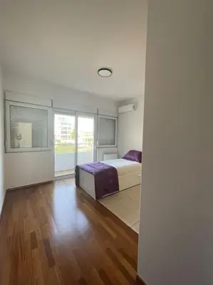 a bedroom with a bed and a large window at Glyfada 3 Bed: Modern & Cozy in Athens