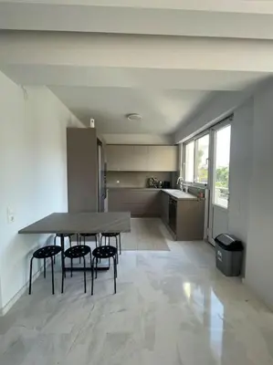 a kitchen with a table and chairs in a room at Glyfada 3 Bed: Modern & Cozy in Athens