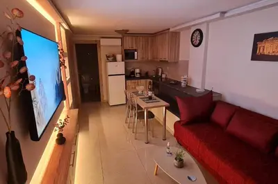 a living room with a red couch and a kitchen at M&S Apartments Athens in Athens