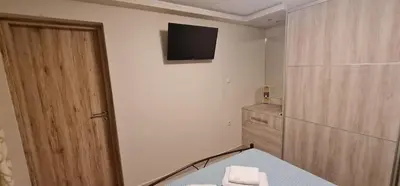 a bathroom with a television and a table with towels at M&S Apartments Athens in Athens