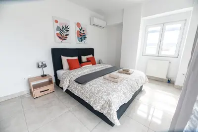 a bedroom with a large bed with orange pillows at Drapetsona Modern Living (DRAP_C2) in Piraeus