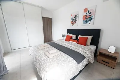 a bedroom with a large bed with orange and black pillows at Drapetsona Modern Living (DRAP_C2) in Piraeus