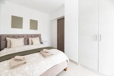 a white bedroom with a bed with towels on it at Drapetsona Modern Living (DRAP_C2) in Piraeus