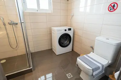 a bathroom with a washing machine and a toilet at Drapetsona Modern Living (DRAP_C2) in Piraeus