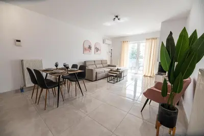 a living room with a table and chairs and a couch at Drapetsona Modern Living (DRAP_C2) in Piraeus
